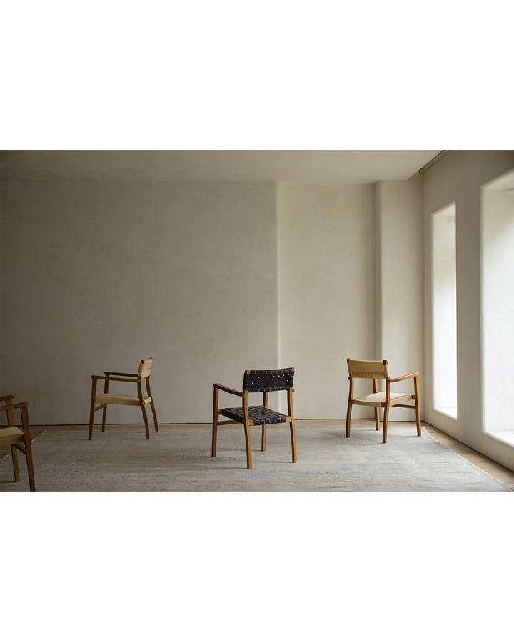 Reed Chairs featuring diverse weaving styles in a minimalistic room with soft lighting.