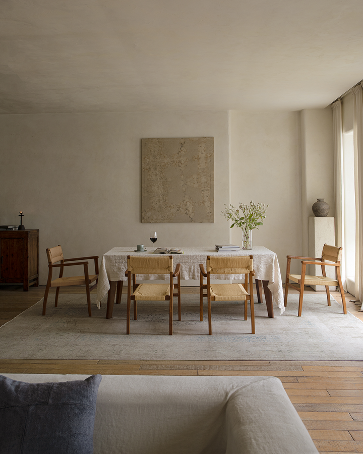 Reed Chairs complementing a wooden table in a serene minimalist dining room.