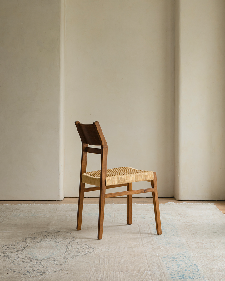 Beam Chair with woven seat, angled view showcasing minimalist design in natural light.