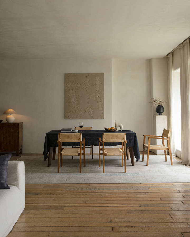 Minimalist dining room featuring Reed Chairs around a wooden table with natural light.