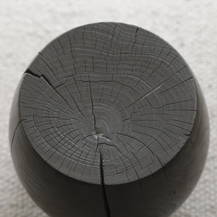 Close-up of black wooden side table showcasing natural cracks and texture.