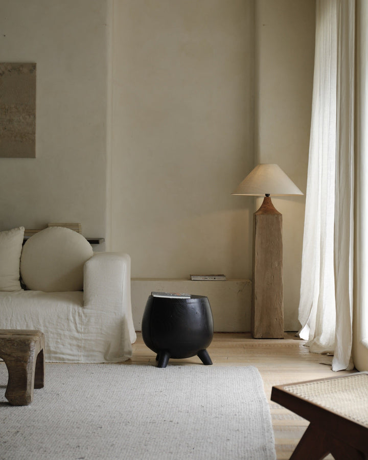 Stylish black side table in a minimalist living room with soft lighting.