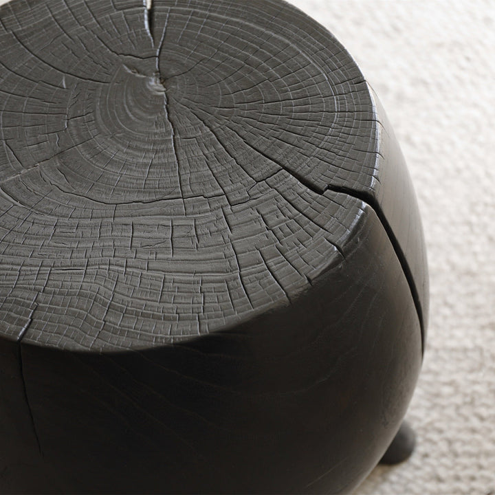 Textured black wood side table with natural cracks, ideal for modern decor.